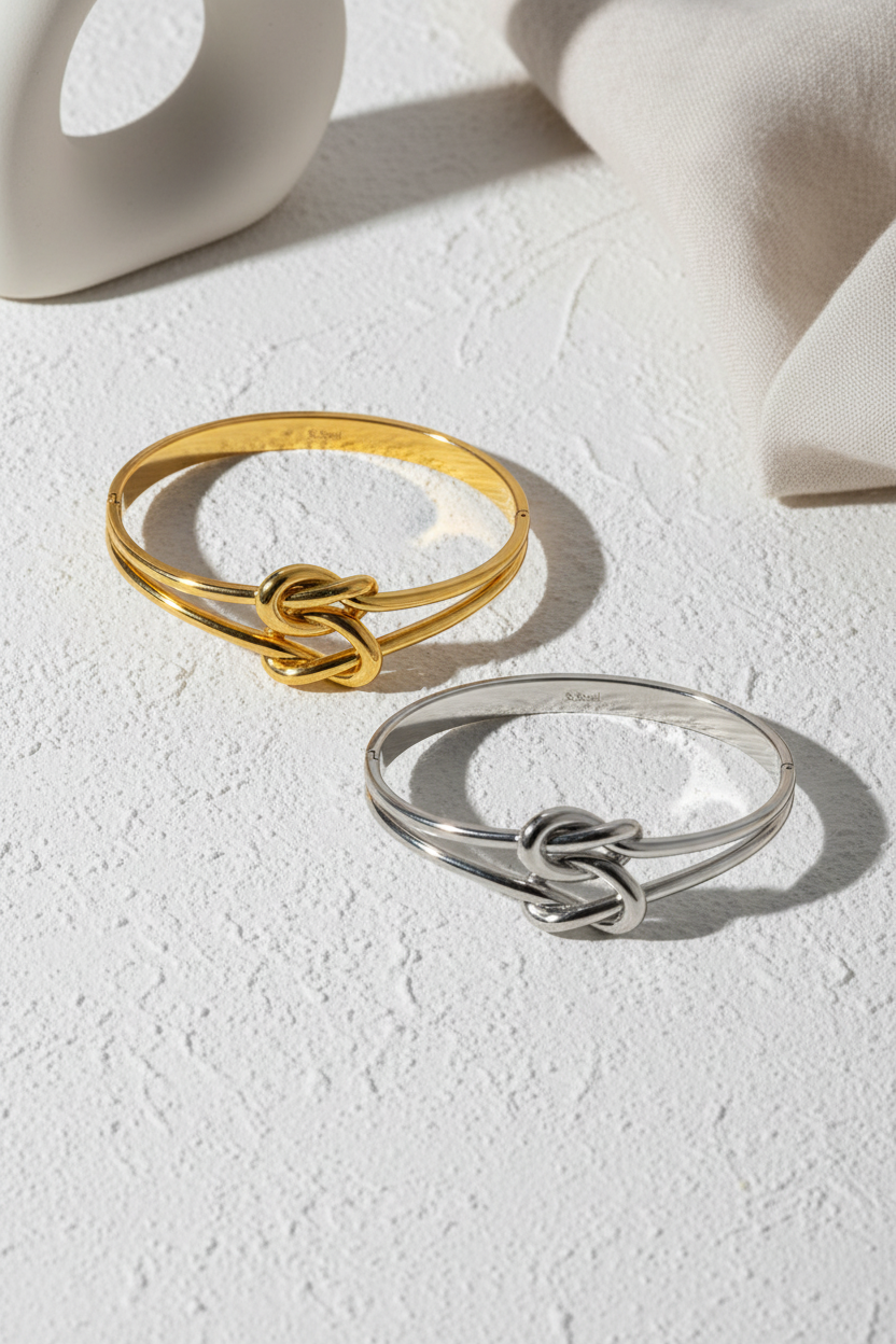 χρυσό και ασημί βραχιόλι bangle με διπλό κόμπο σε μινιμαλ κυκλαδίτικο σκηνικό κοντινό