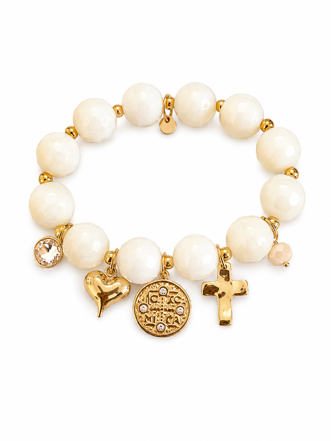 A beaded stretch bracelet featuring white pearl-like beads, gold-tone spacer rings, and three dangling charms: a small clear rhinestone charm, a gold heart charm, a round gold medallion charm, and a gold cross charm, all displayed on a clean white background.