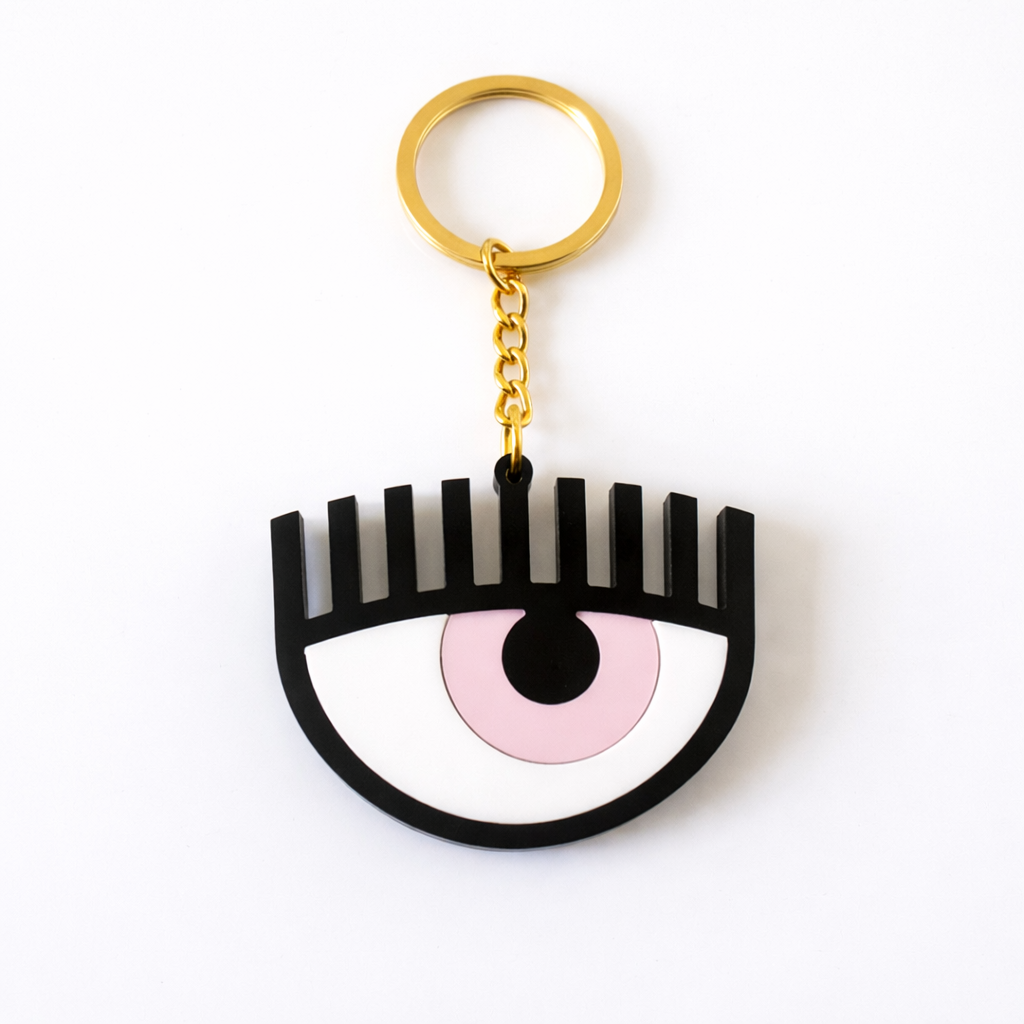 Keychain shaped like an eye with a pink center and black outline on a white background