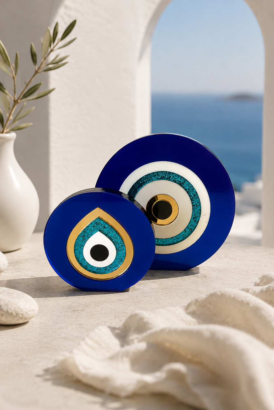 Paros Eye acrylic evil eye tabletop sculptures in cobalt blue and gold mirror styled together in a luxury Mediterranean interior