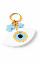 Keychain with blue eye charm, star, and cross on a white base