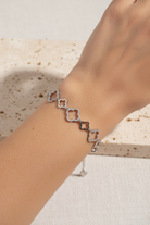 Βραχιόλι Clover Outline από ανοξείδωτο ατσάλι με εναλλασσόμενα μοτίφ τετράφυλλου και μεγάλα περιγράμματα διακοσμημένα με ζιργκόν, φορεμένο σε μοντέλο