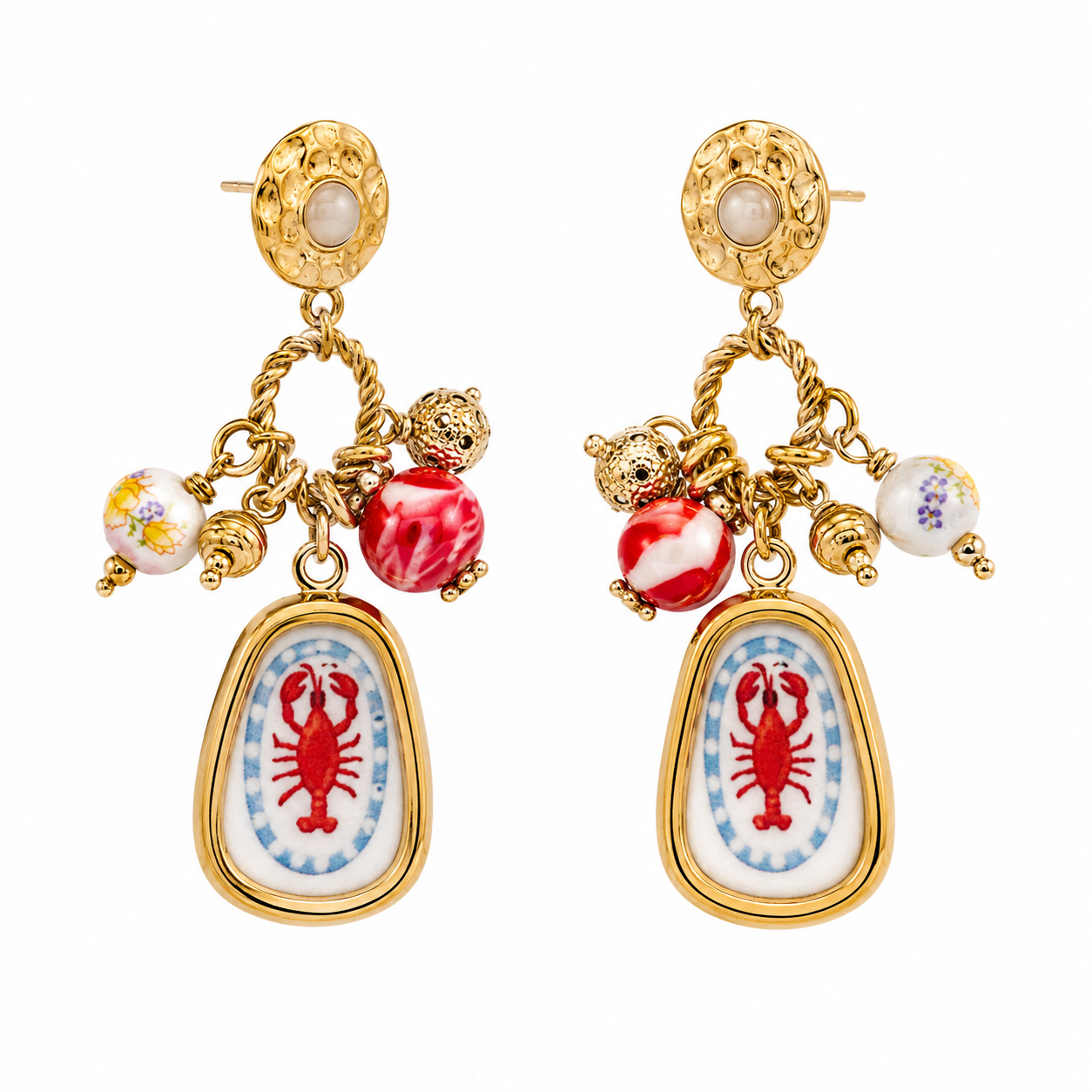 Ατσάλινα statement σκουλαρίκια So Cute by Dimi με lobster charms, χρυσές λεπτομέρειες και decorative χάντρες σε Mediterranean resort αισθητική.