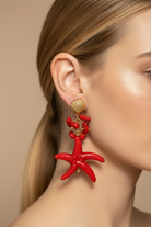 Ατσάλινα κρεμαστά σκουλαρίκια Coral Starfish Earrings με κόκκινο αστερία, κοραλλί λεπτομέρειες και χρυσό κοχύλι από το So Cute by Dimi, φορεμένα σε μοντέλο