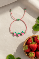 Παιδικό χειροποίητο μαρτάκι Strawberry Smile με κόκκινο-λευκό κορδόνι, γυάλινες χάντρες και τρεις χάντρες φράουλα από φίμο, So Cute by  Dimi