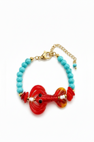 A handmade glass bead bracelet featuring a red lobster charm, turquoise blue beads, gold-tone chain extender, and a white brand tag that reads 'Socute Handmade Jewelry'.
