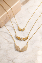 Gold necklaces with intricate designs on a marble surface