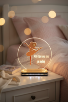 Decorative night light with a ballerina design on a bedside table.