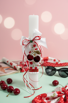 Χειροποίητη πασχαλινή λαμπάδα με cherry print σατέν ύφασμα, σατέν φιόγκους, πράσινο κρύσταλλο και μπρελόκ κεράσι από πλεξιγκλάς. So Cute by Dimi