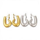 Pair of gold hoop earrings and pair of silver hoop earrings on a white background