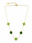 Gold necklace with green clover-shaped pendants on a white background