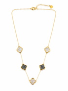 Gold necklace with clover-like stones on a white background