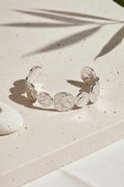Coin Muse Bracelet σε ασημί χρώμα, ατσάλινο βραχιόλι με νομίσματα σε minimal flatlay