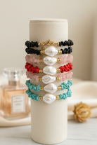 Set of colorful beaded bracelets on a white cylindrical holder with a blurred background.