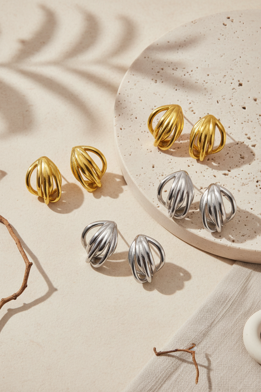 Contour Sculptural Earrings σε editorial flatlay με χρυσό, ασημί και δίχρωμο φινίρισμα σε minimal σκηνικό