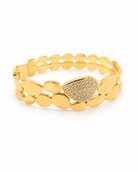 Ατσάλινο bangle βραχιόλι Electra Shine με oval μεταλλικά στοιχεία και λαμπερό μοτίφ ζιργκόν σε χρυσό χρώμα σε λευκό φόντο.