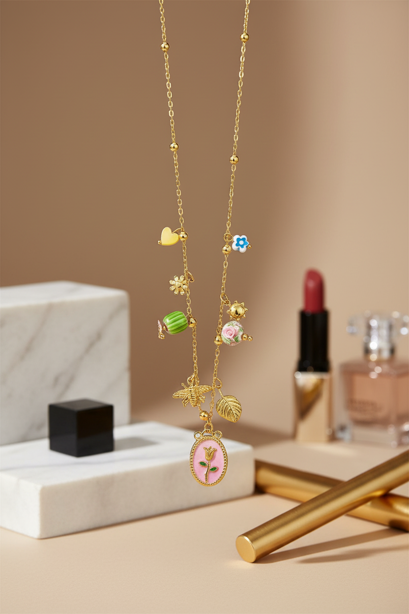 Gold necklace with charms on a beige surface with makeup items in the background