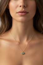 Close-up of a woman wearing a gold necklace with a elephant pendant.