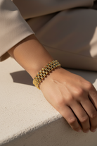 Gold stainless steel pyramid link bracelet worn on wrist, geometric stud bracelet close up jewelry
