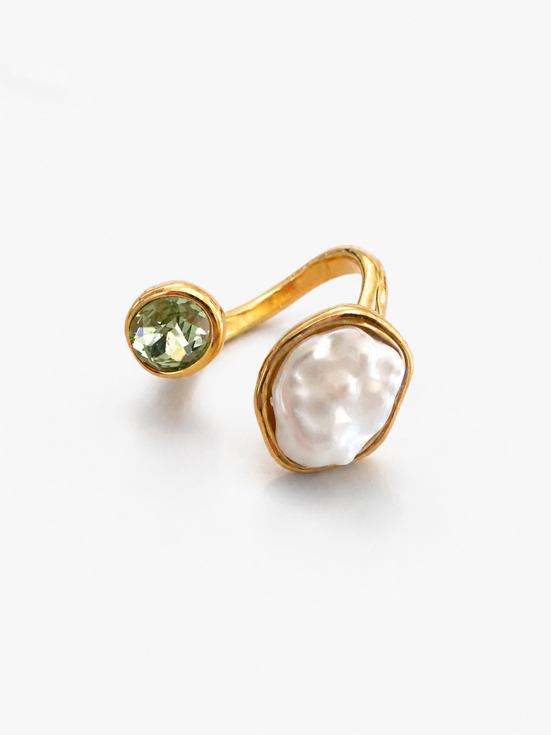 Ατσάλινο χρυσό δαχτυλίδι με organic pearl στοιχείο και χρωματιστό zircon σε minimal luxury αισθητική.