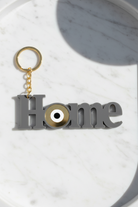 Χειροποίητο μπρελόκ HOME από γκρι plexiglass με μάτι σε χρυσό καθρέφτη – So Cute by Dimi