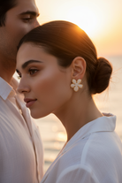 Woman wearing floral earrings with a blurred background