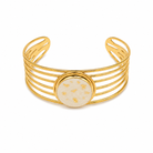 Gold bracelet with a central circular design on a white background