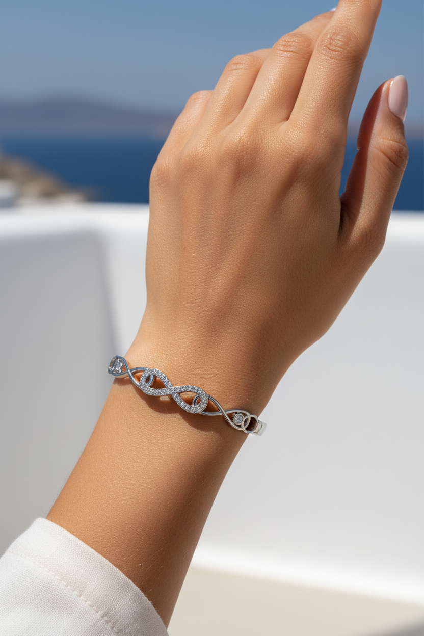 Ατσάλινο βραχιόλι Line Infinity Bracelet σε ασημι με σύμβολο infinity και πέτρες, φορεμένο σε μοντέλο με καλοκαιρινο φόντο, So Cute by Dimi