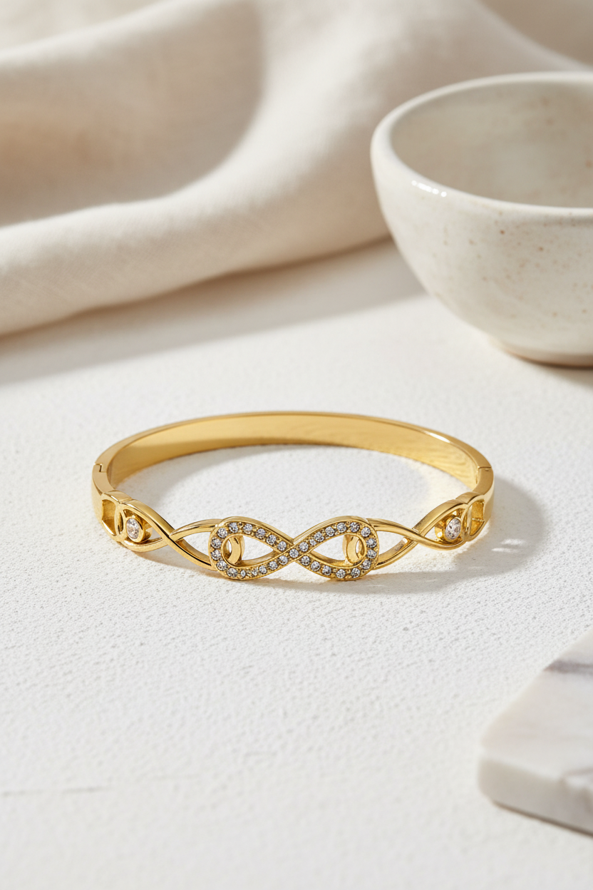 Ατσάλινο βραχιόλι Line Infinity Bracelet σε χρυσό  με σύμβολο infinity και πέτρες, σε μινιμαλ neutral φόντο, So Cute by Dimi