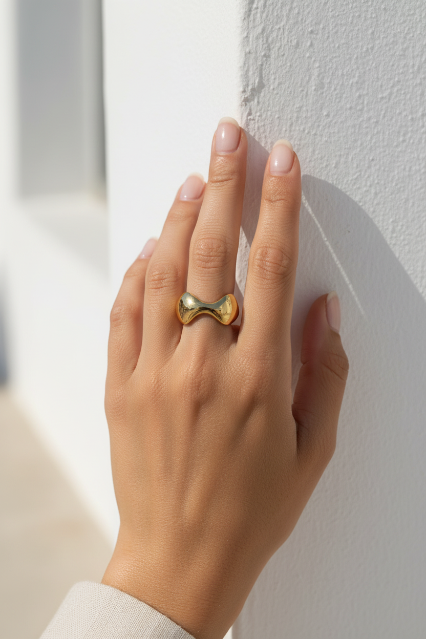 Ατσάλινο δαχτυλίδι Mira Tide Ring χρυσό φορεμένο σε γυναικείο χέρι σε minimal κυκλαδίτικο σκηνικό So Cute by Dimi