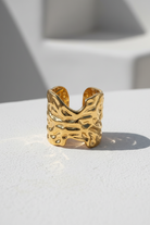 Ατσάλινο δαχτυλίδι Molten Form χρυσό με organic textured design σε minimal κυκλαδίτικο σκηνικό So Cute by Dimi