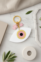 Keychain with eye design and pink stars on a marble surface