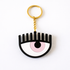 Keychain shaped like an eye with a pink center and black outline on a white background