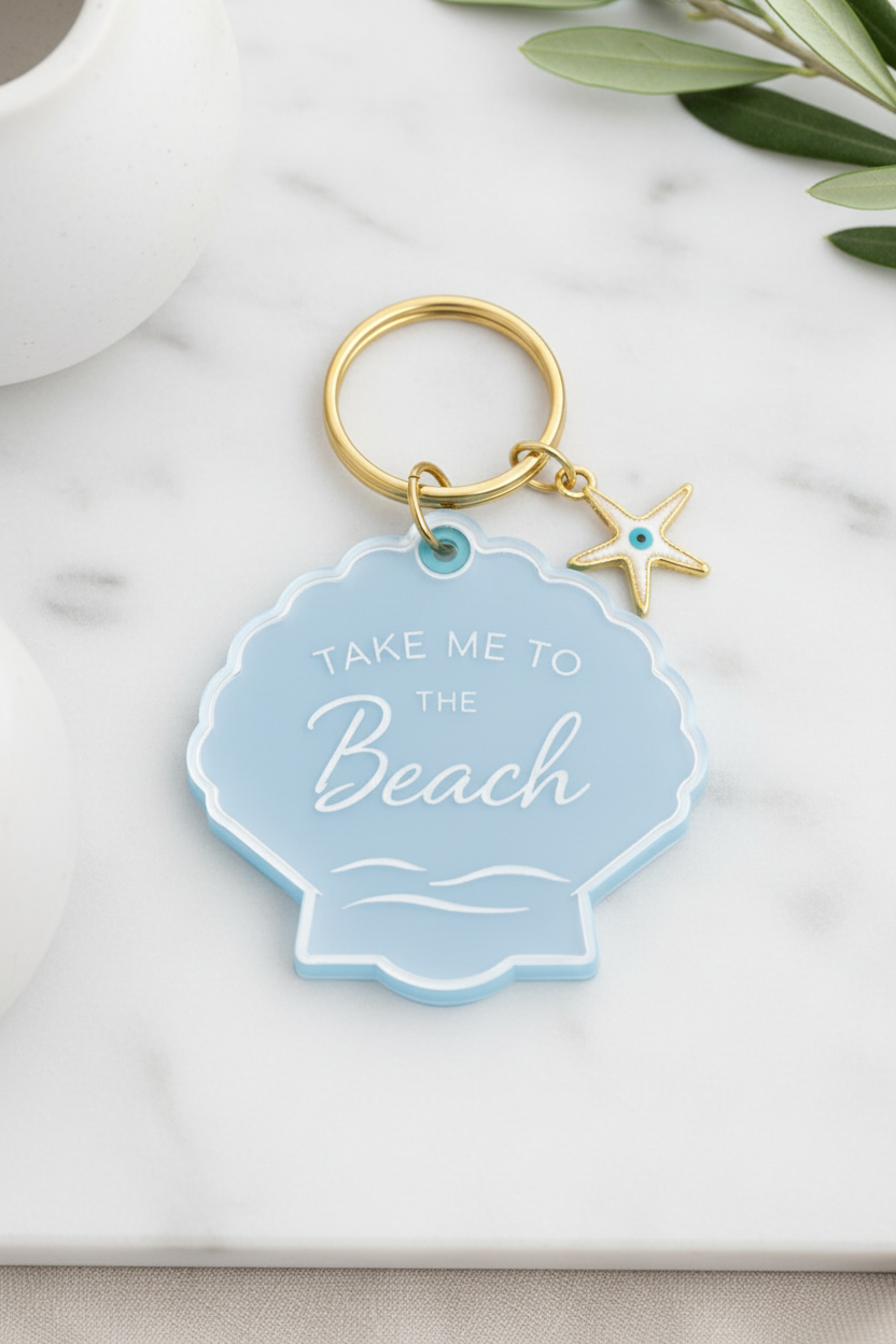 Keychain with 'Take Me to the Beach' tag and starfish charm on marble surface