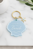 Keychain with 'Take Me to the Beach' tag and starfish charm on marble surface