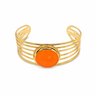 Gold bracelet with an orange circular stone on a white background