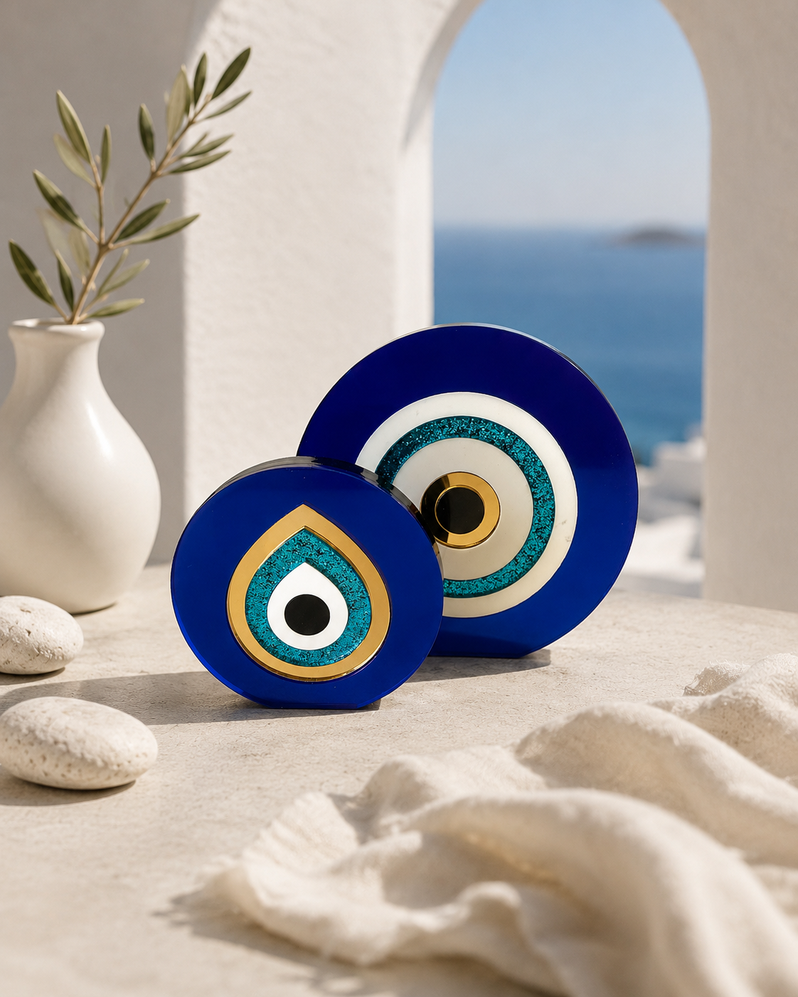 Paros Eye acrylic evil eye tabletop sculptures in cobalt blue and gold mirror styled together in a luxury Mediterranean interior