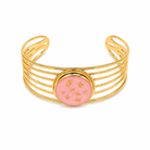 Gold bracelet with a pink center on a white background