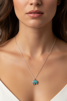 Necklace with a turquoise elephant pendant worn by a model
