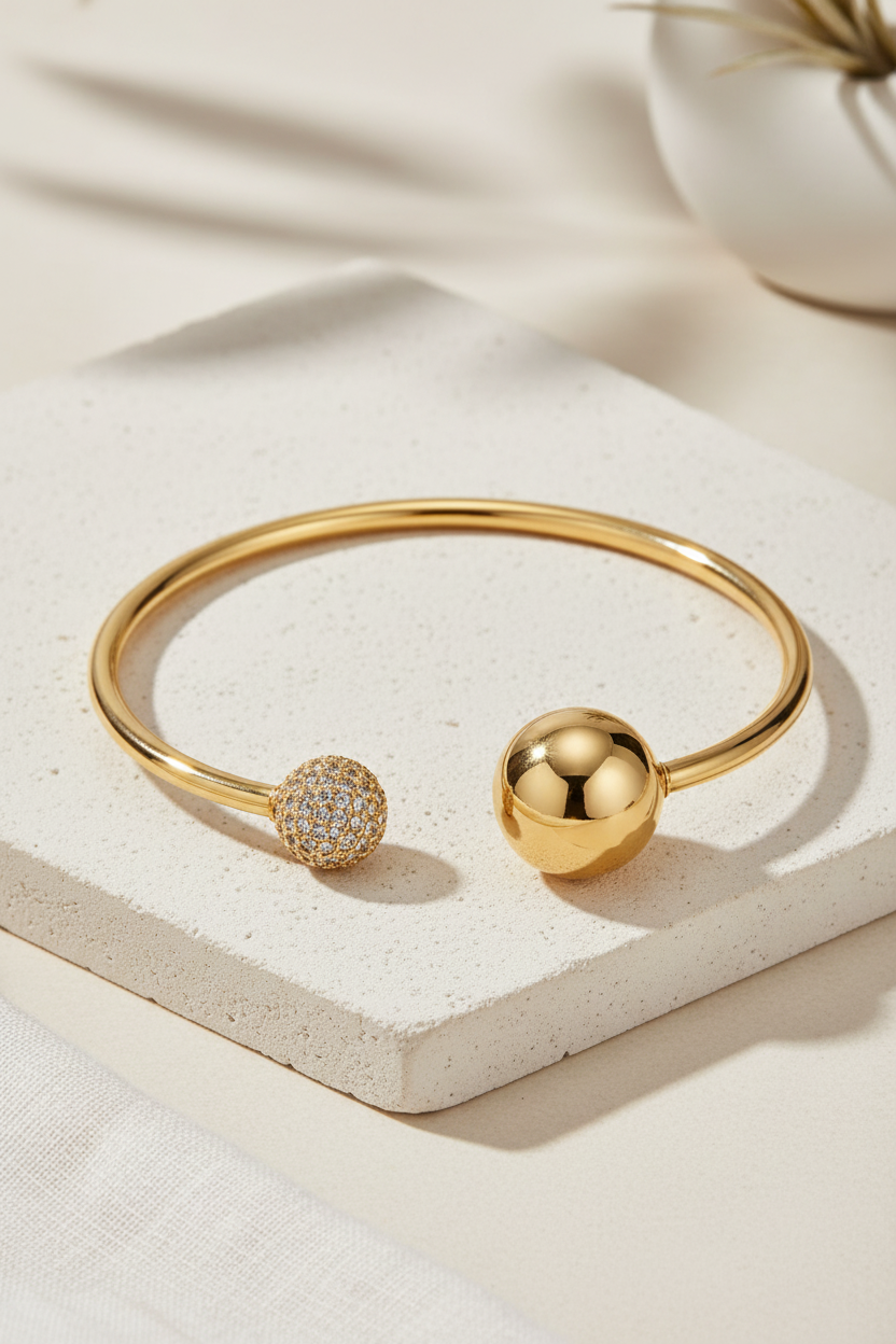 Sphere Glow Bangle σε χρυσό χρώμα, ατσάλινο βραχιόλι bangle με ζιργκόν σε minimal stone flatlay