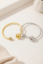 Sphere Glow Bangle σε χρυσό και ασημί χρώμα, ατσάλινο βραχιόλι bangle με μπίλιες και ζιργκόν σε minimal flatlay