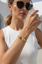 Φορεμένο Sphere Glow Bangle σε χρυσό χρώμα, ατσάλινο βραχιόλι με μπίλιες και ζιργκόν