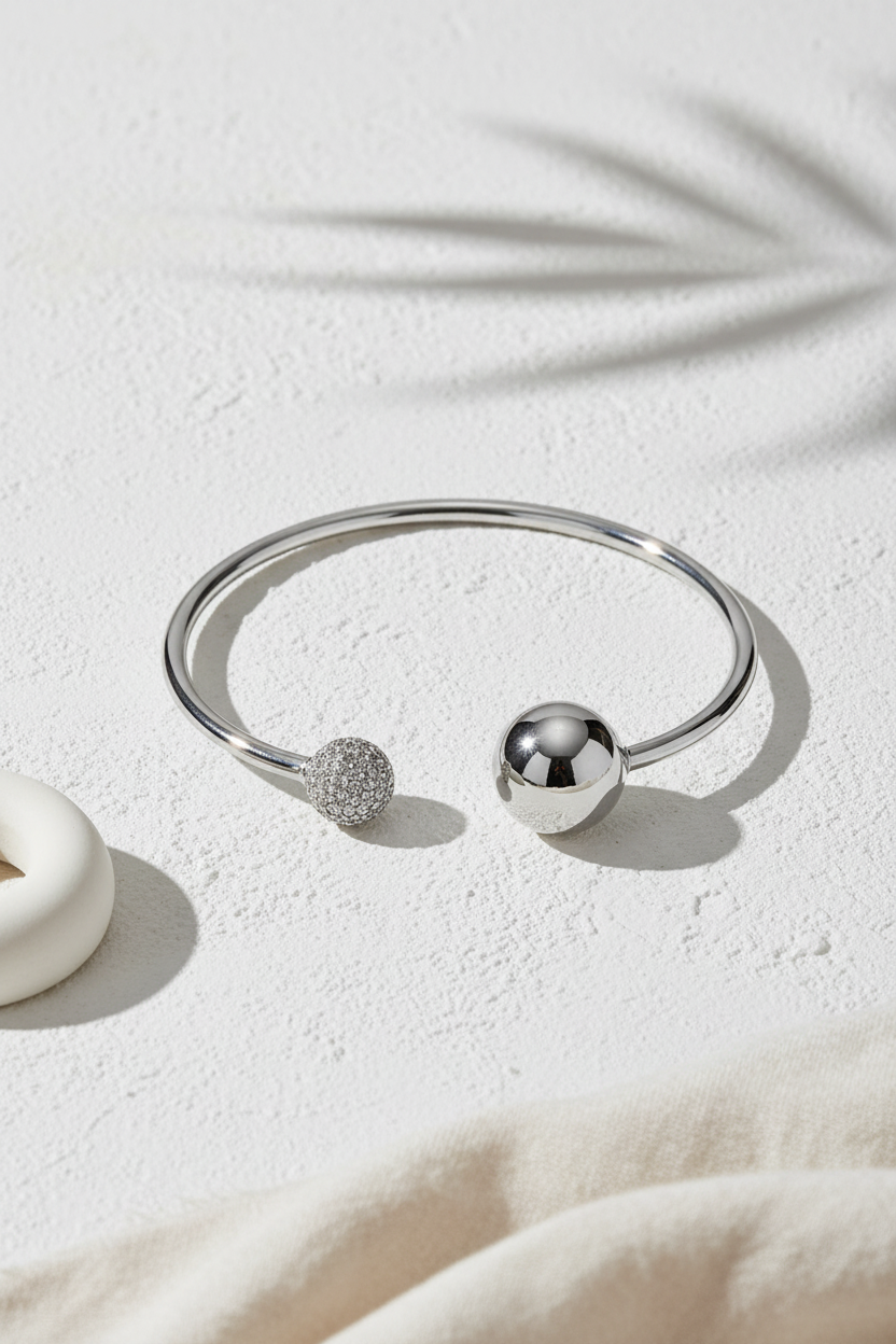 Sphere Glow Bangle σε ασημί χρώμα, ατσάλινο βραχιόλι bangle με ζιργκόν σε minimal stone flatlay