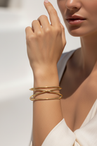 Ατσάλινο cuff βραχιόλι Flow Line σε χρυσό με minimal καμπύλες γραμμές, φορεμένο σε μοντέλο, So Cute by Dimi