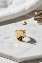 Zirelle open ring σε χρυσό πάνω σε marble επιφάνεια σε minimal καλοκαιρινό flatlay