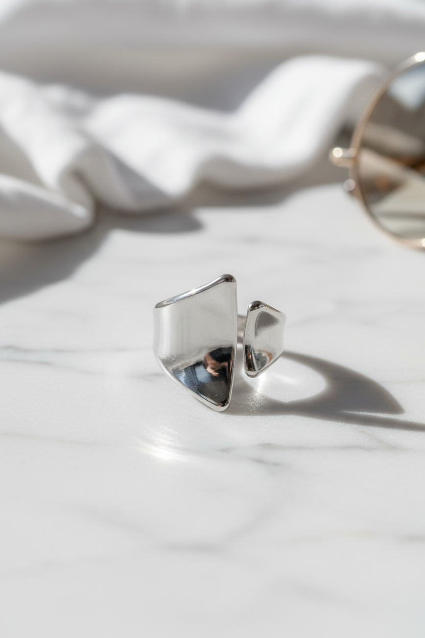 Minimal ασημί open ring σε καθαρό flatlay με luxury αισθητική και φυσικό φως