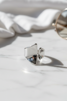 Minimal ασημί open ring σε καθαρό flatlay με luxury αισθητική και φυσικό φως